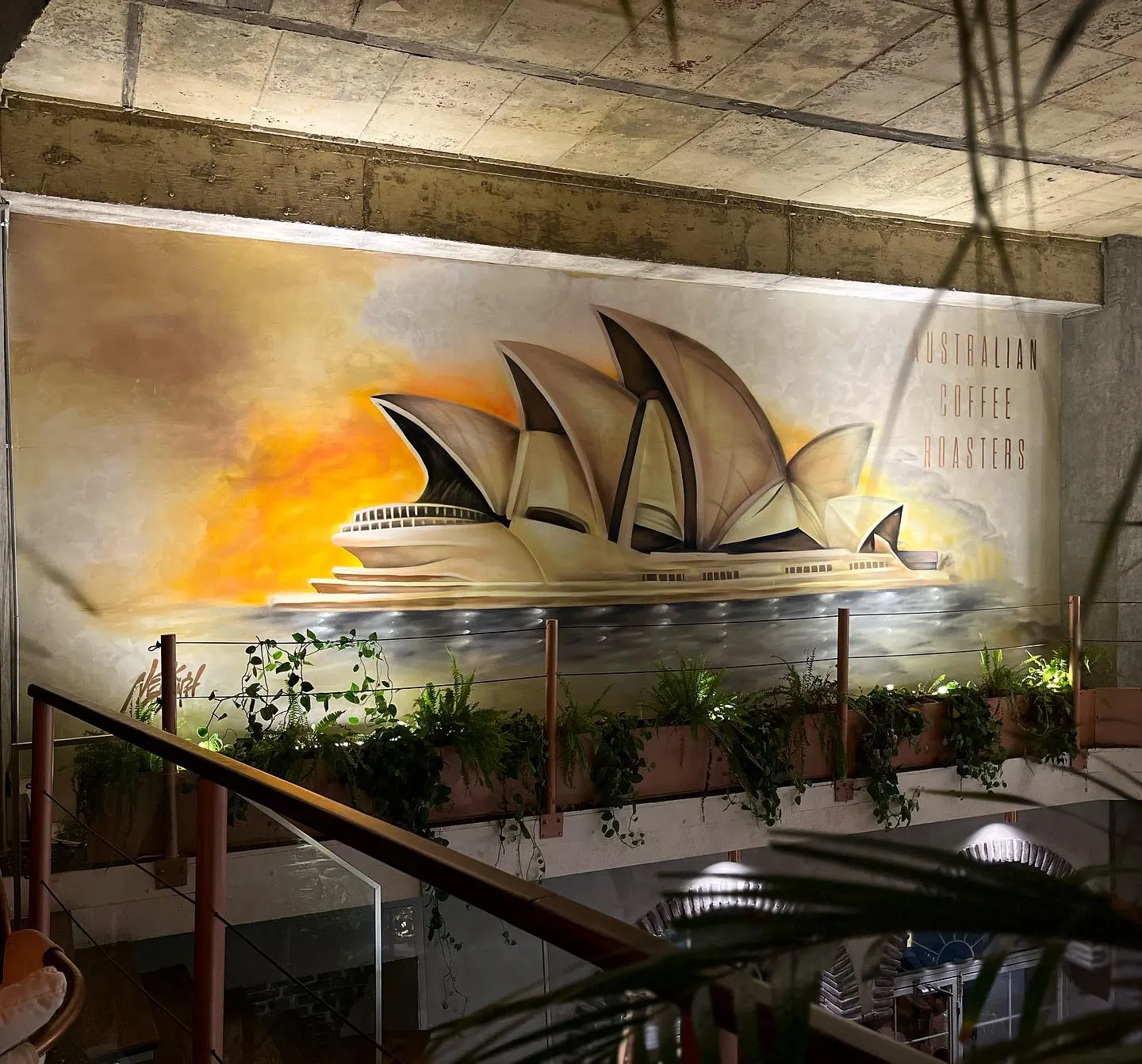 Gün batımında Sidney Opera Binası resmedilmiş kafe duvarı
